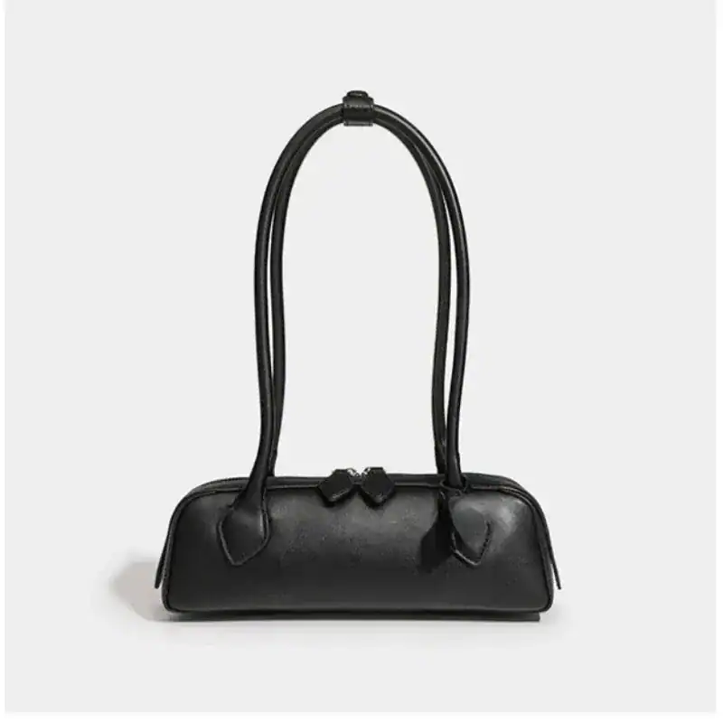 Krämvit handväska, svart läder, elegant axelväska med hög handtag.