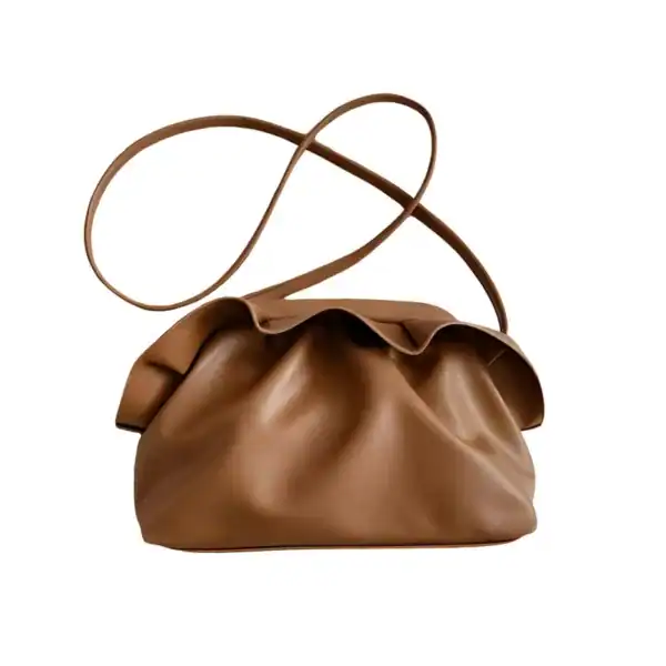 Krämvit molnväska i läder, elegant axelväska med slinga och mjuk form.