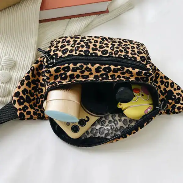 Leopardmönstrad bältesväska med öppen ficka och innehåll.