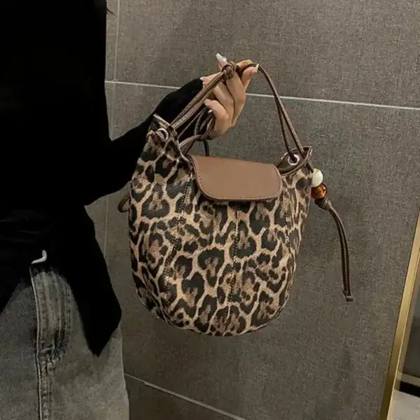 Leopard mönster halvmånsväska med läderficka och handtag.