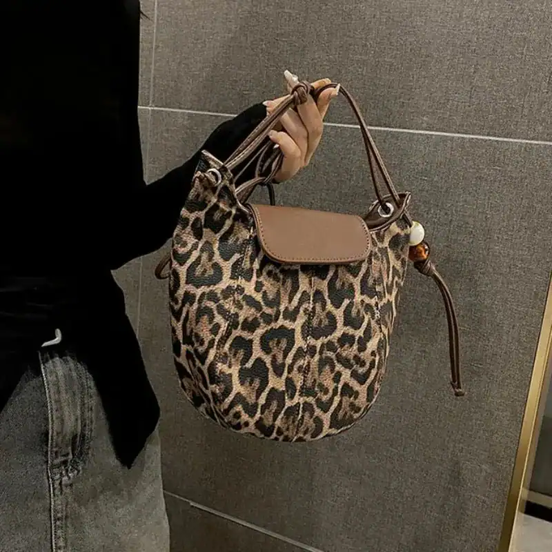 Leopard mönster halvmånsväska med läderficka och handtag.