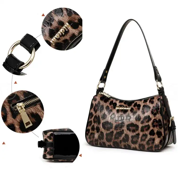 Leopard hobo väska med svart krokodiltextur och guldaktiga dragkedjor.
