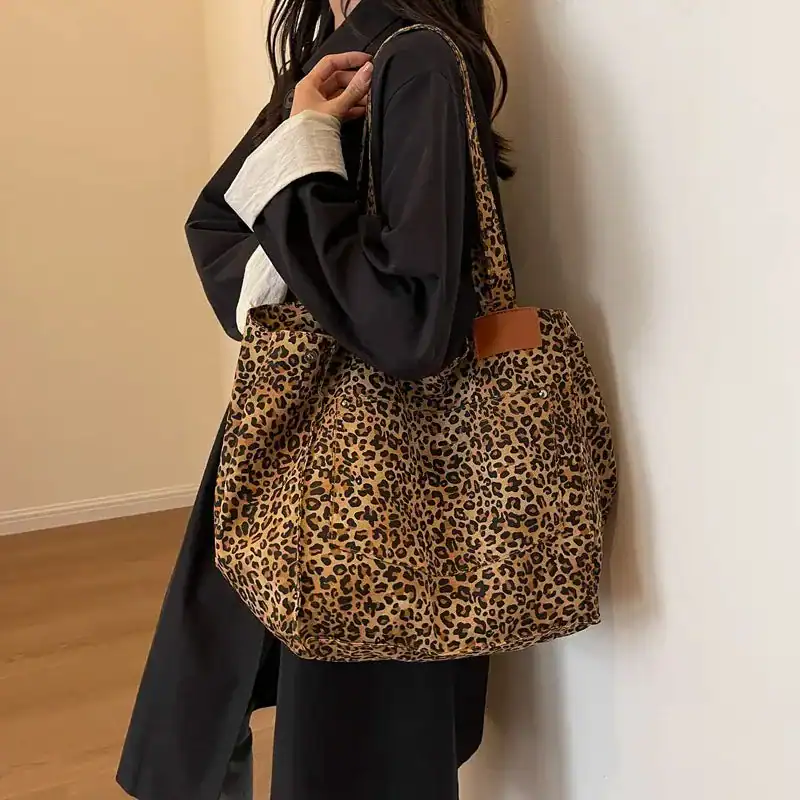 Leopard mökkaväska i stoff, stor axelväska med läderplatta och handtag.