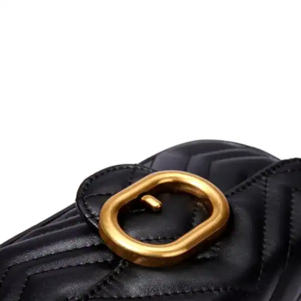 Liten svart handväska med guldpläterad ring och quiltad yta.