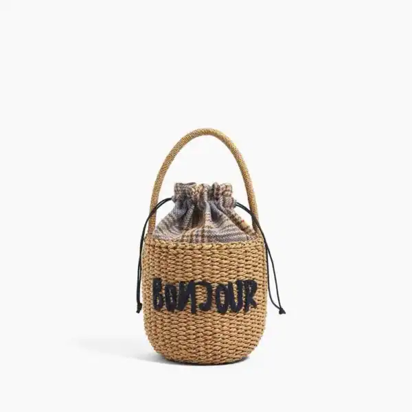 Liten stråväska med text 'BONJOUR', dragsnörd, handtag, sommarväska.