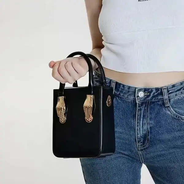 Liten svart shoppingväska med guldhandtag, modeaccessoarer för kvinnor.