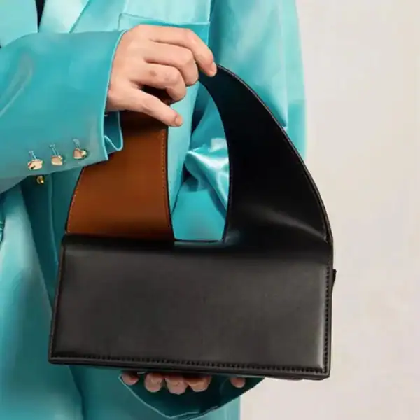 Liten svart väska med brunt handtag, modeaccessoarer, elegant axelväska.