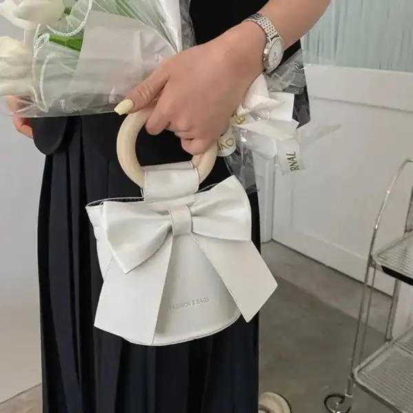 Ljusblå väska med stor rosett och runt handtag, modeaccessoarer för kvinnor.