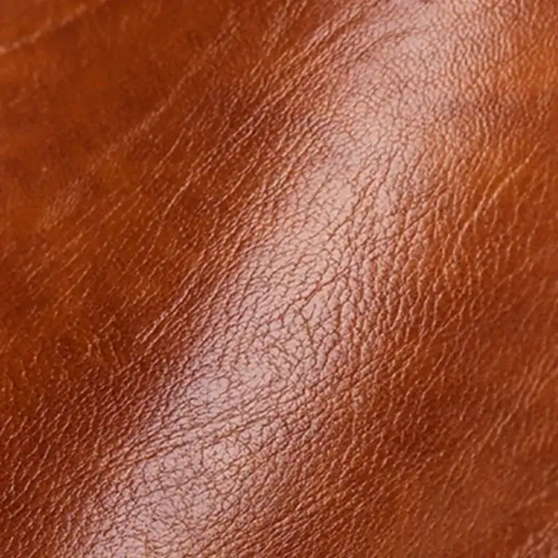 Marinblå hoboväska, närbild av brun läderytta med naturlig textur.