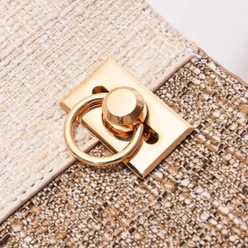 Marinblå tvåfärgad hinkväska med guldaktig metallhållare och texturerat material.
