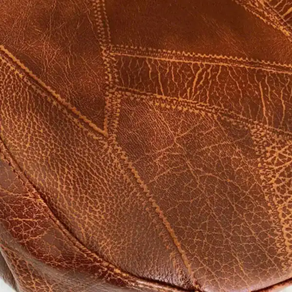 Metallic hobo väska i brunt läder med detaljerad sömmar och textur.