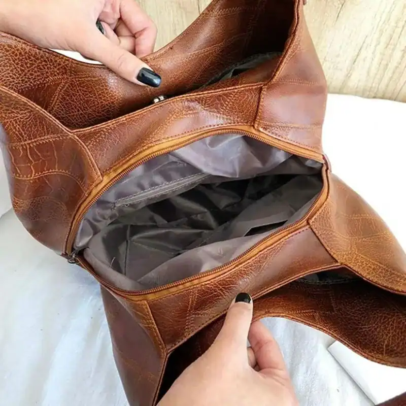 Metallic hobo väska i brunt läder med inre fack och dragkedja.