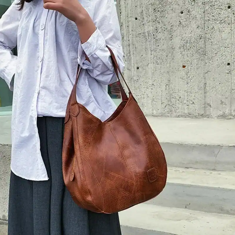 Metallic hobo väska i brunt läder, bära över axeln eller i handen.