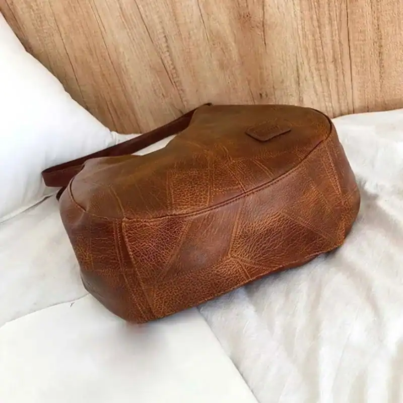 Metallic hobo väska i brunt läder med geometriskt mönster, perfekt för vardag och stil.