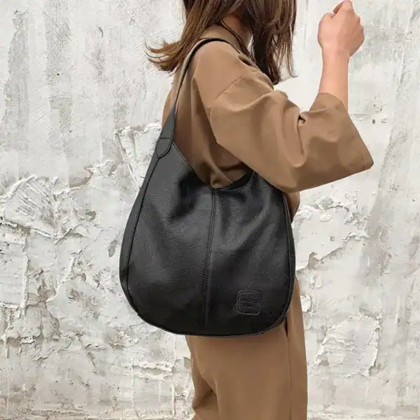 Metallic hobo väska i svart, modell med texturerad yta och axelrem.