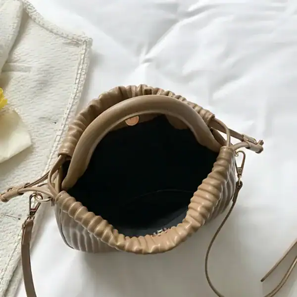Mintgrön plisserad väska med handtag och axelrem, trendig modeaccessoar.