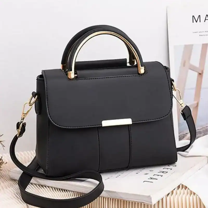 Svart axelväska med metallhandtag och axelrem, elegant damväskor.