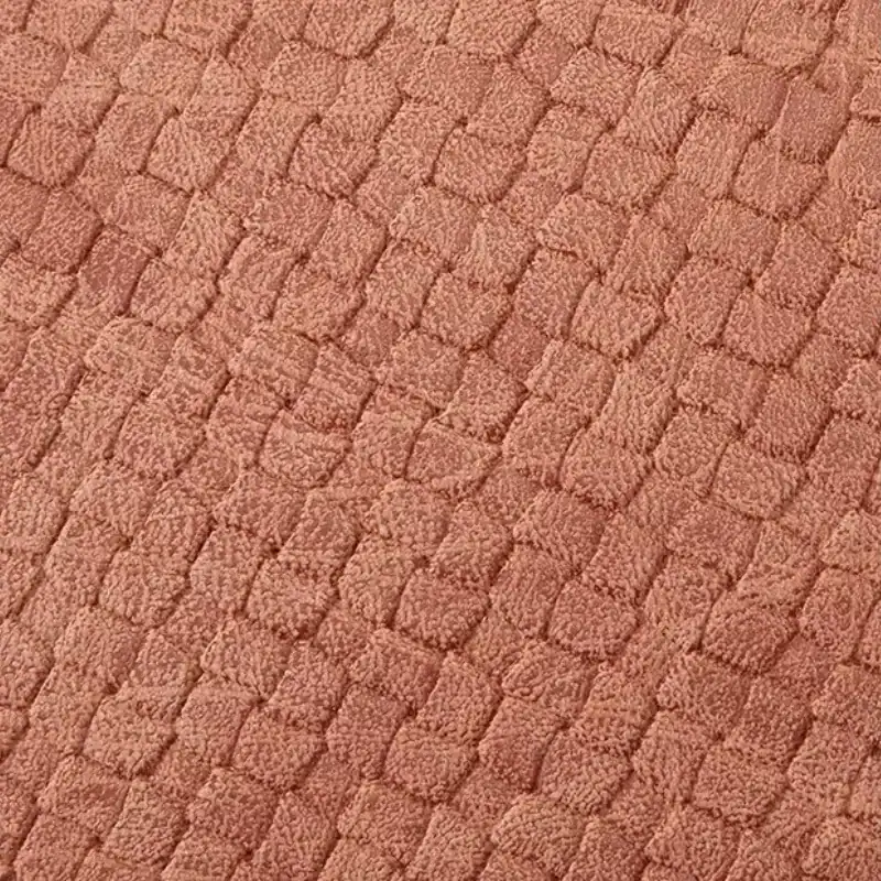 Mintgrön väskset med mjuk, texturerad yta och färgstarkt rosa ton.