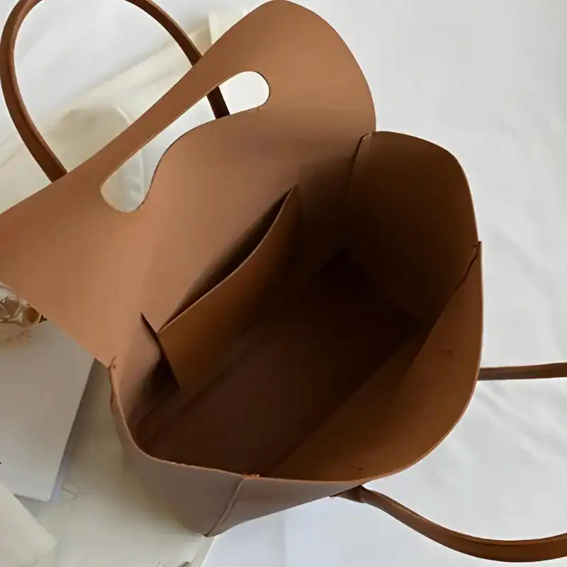 Mörkbrun shopper med inbyggd plånboksfack och runt handtag.