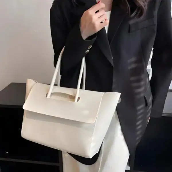 Mörkbrun shopper axelväska, elegant handväska med vita handtag och minimalistisk design.