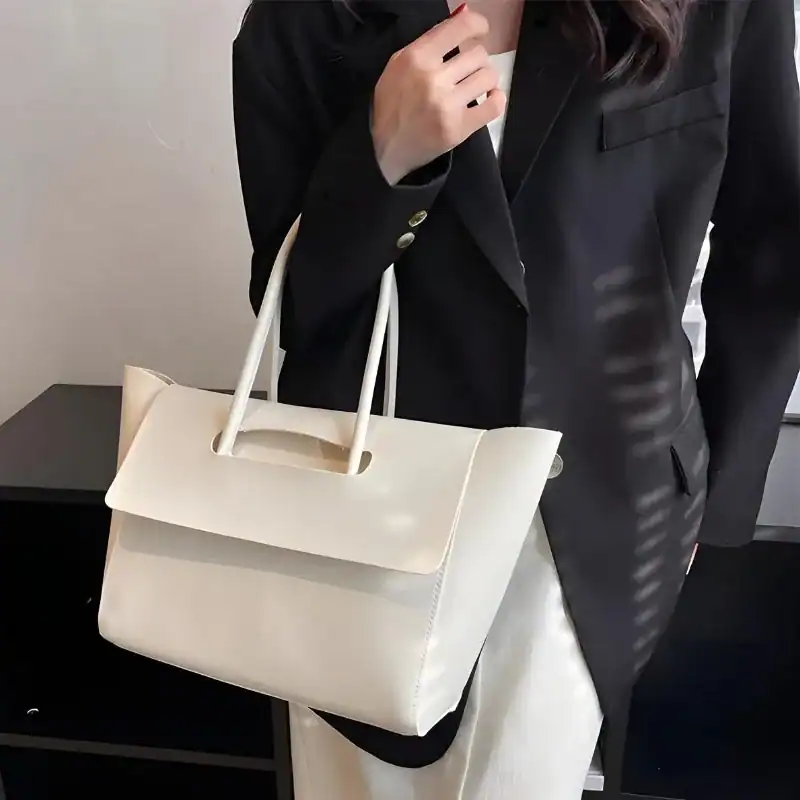 Mörkbrun shopper axelväska, elegant handväska med vita handtag och minimalistisk design.