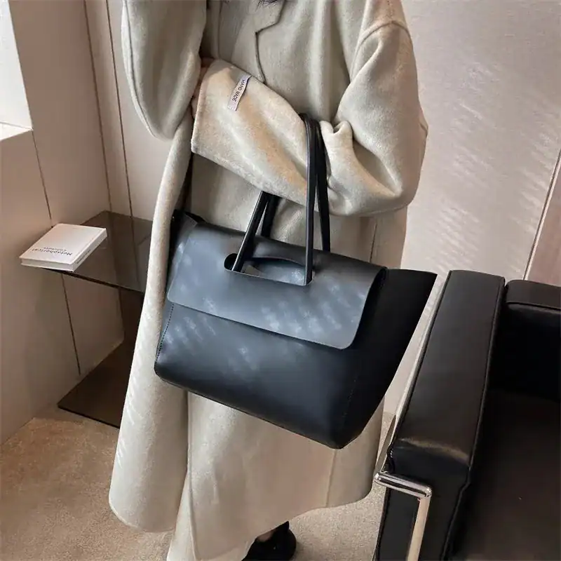 Mörkbrun shopper axelväska med korta handtag, trendig och elegant för vardag.