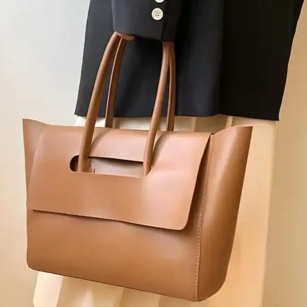 Mörkbrun shopper axelväska med handtag, läder, minimalistisk design.