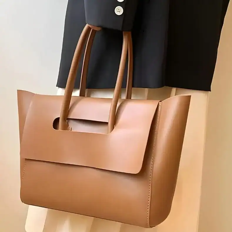 Mörkbrun shopper axelväska med handtag, läder, minimalistisk design.