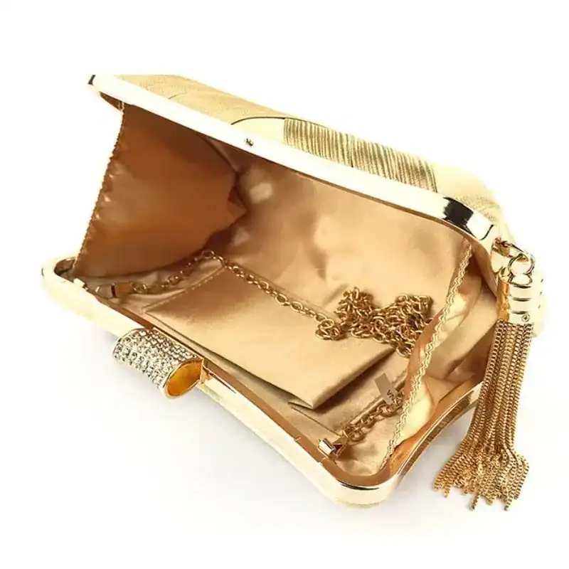 Mörkgrön festclutch med guld detaljer och pärlkedja.