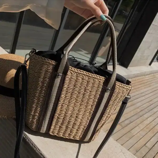 Randig strandkorg i röd och beige, med handtag och axelrem för strand eller dagutomhus.