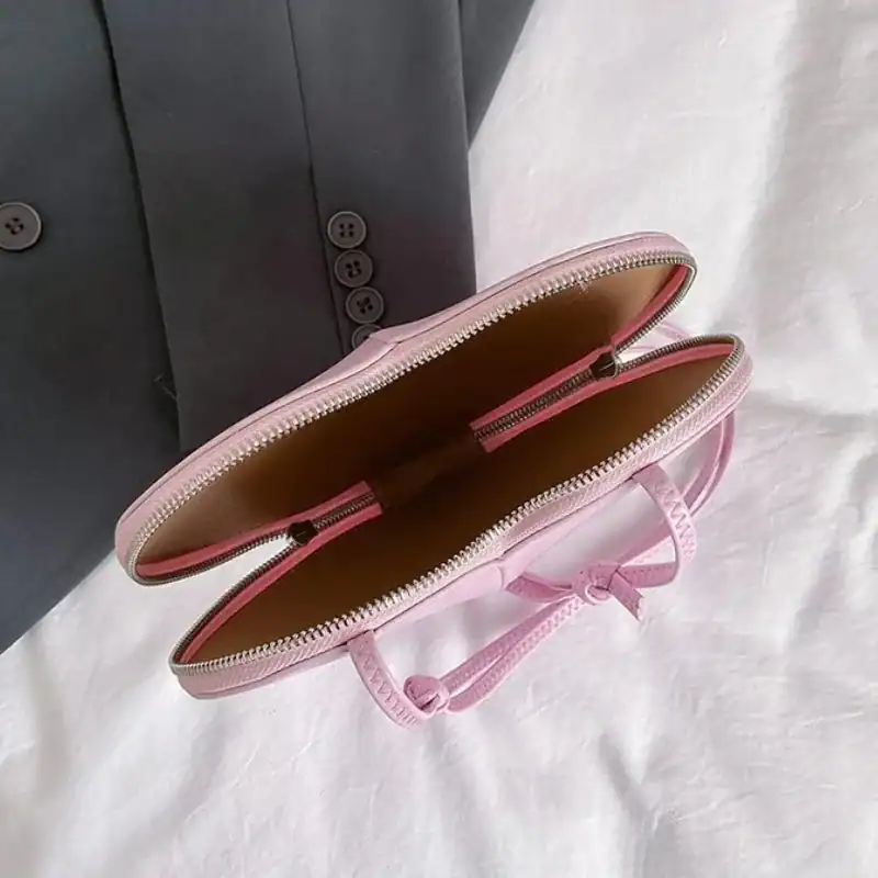 Röd hjärtväska, rosa axelväska med dragkedja och handtag.