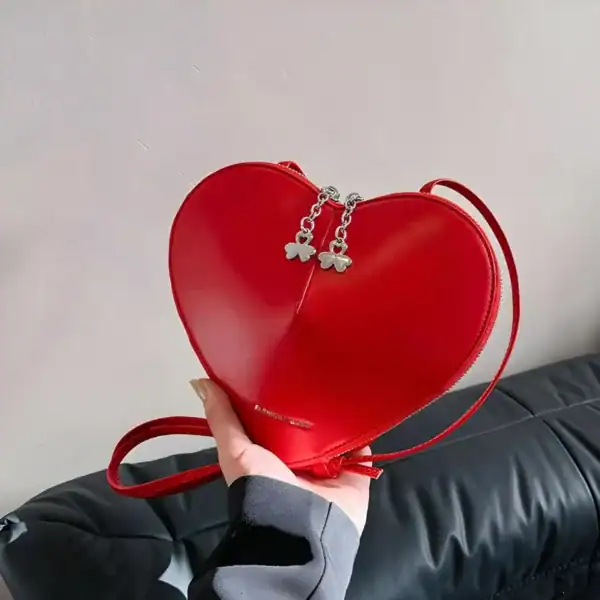 Röd hjärtväska med silverfärgad fjärilskedja och axelrem, perfekt för romantiska tillfällen.