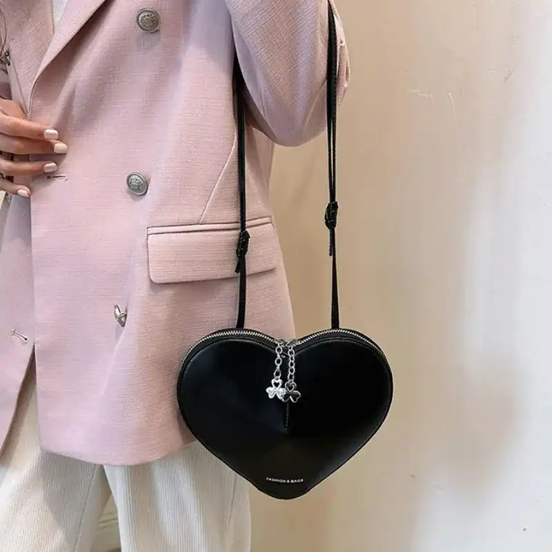 Röd hjärtväska, svart hjärtaformad axelväska med silverfärgad hängande fjäril.