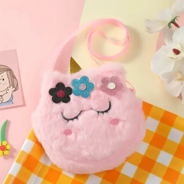 Rosa barnryggsäck i form av en fluffig enhörning med blommor och gyllene horn.