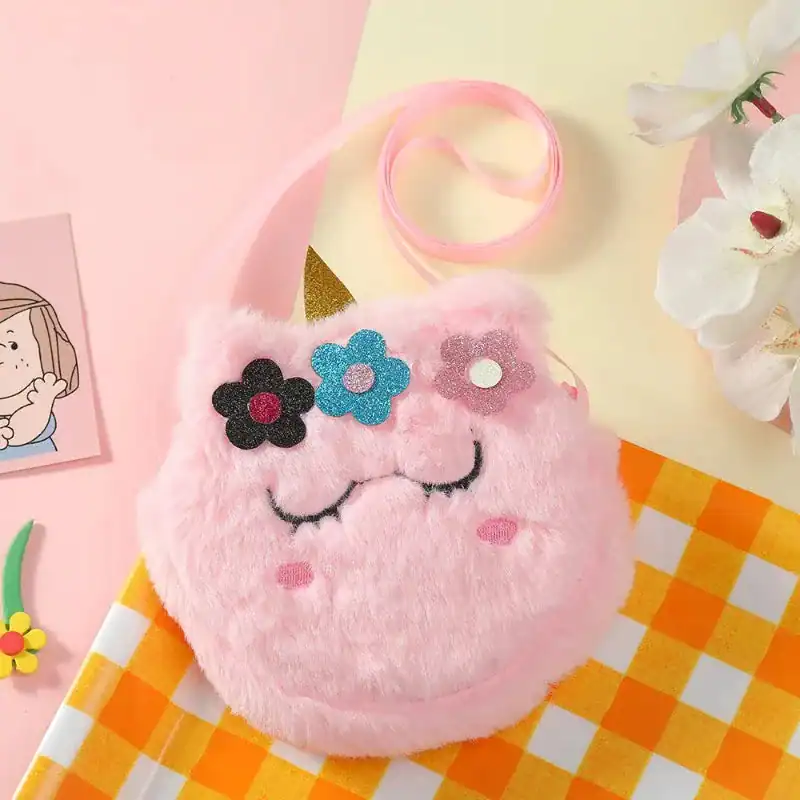 Rosa barnryggsäck i form av en fluffig enhörning med blommor och gyllene horn.