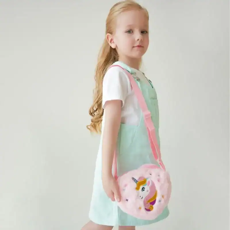 Liten flicka med rosa enhörningsväska i form av donut.