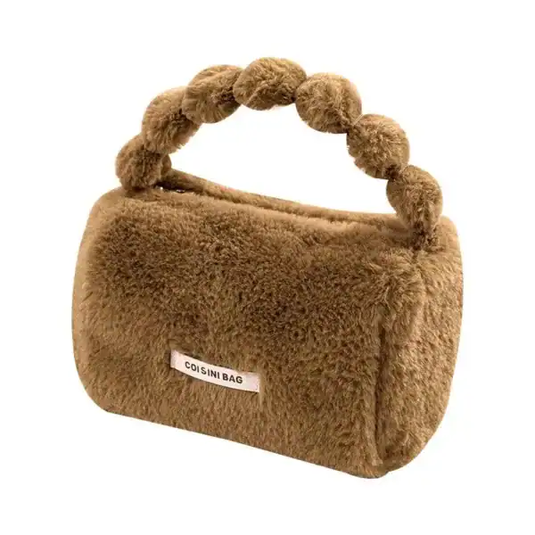 Rosa fluffig väska med pärlformad handtag och etikett.