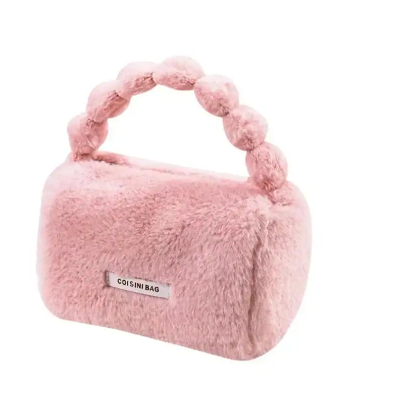 Rosa fluffig väska med pärlformad handtag och etikett.