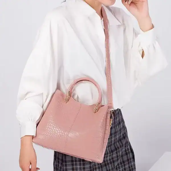 Rosa krokodilmönstrad väska med handtag och axelrem, modeaccessoarer för kvinnor.