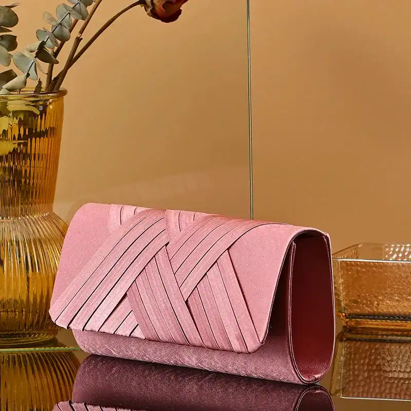 Rosa kuvertväska med färgglad vävtextur och elegant design.