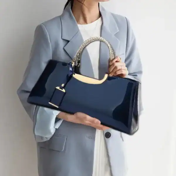 Rosa lack handväska med silverfärgad handtag och guldaccent.
