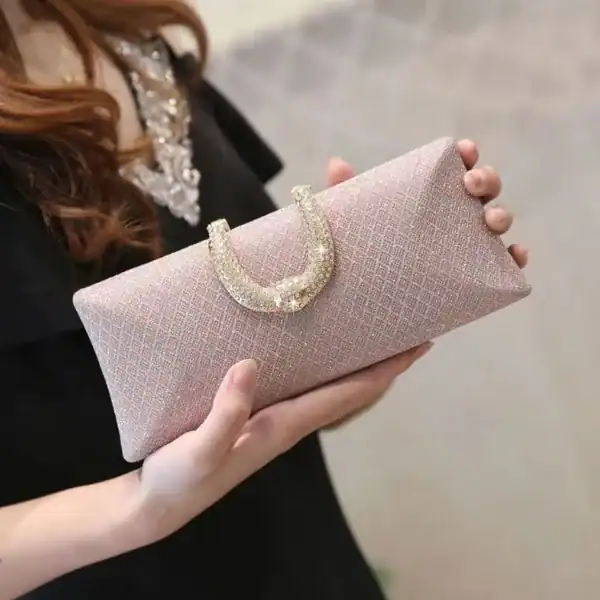 Rosa rutmönstrad clutch med glittrande handtag och elegant design.