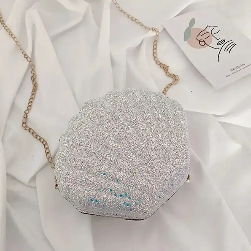 Rosa snäckväska med glitter och gyllene kedja, perfekt för festliga tillfällen.