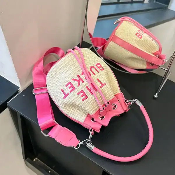 Rosa stråväska med text 'THE BUCKET' och axelrem, sommarväska för kvinnor.