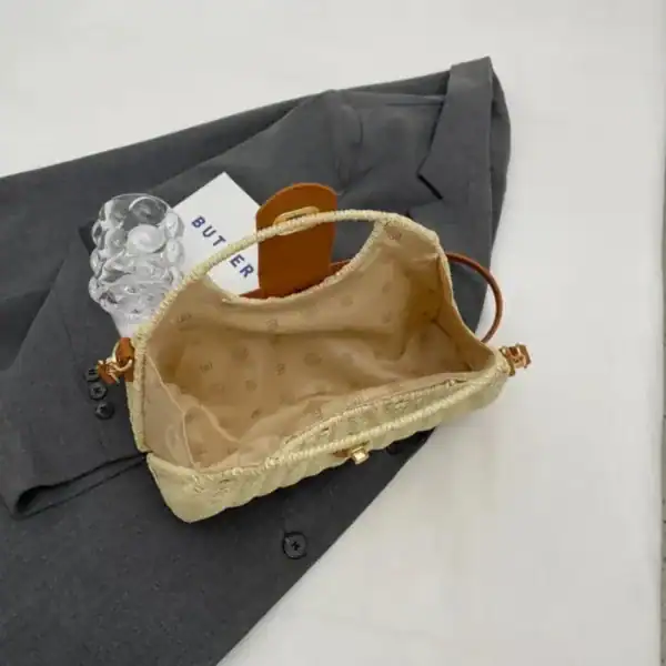 Rottingväska med lås, beige, innehåll och inre yta synlig.