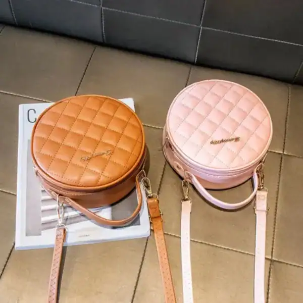 Rund rutmönstrad väska i beige och rosa, axelväska med axelrem och handtag.