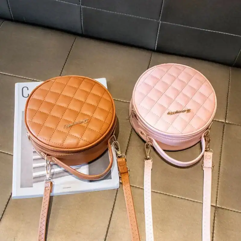 Rund rutmönstrad väska i beige och rosa, axelväska med axelrem och handtag.