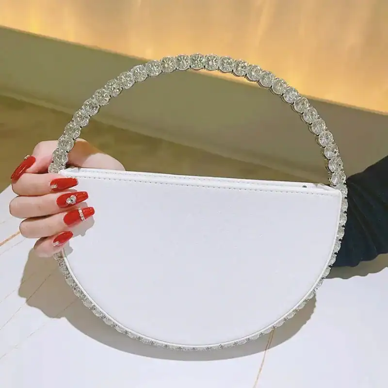 Vit rund clutch med strass på handtag, elegant kvällsaccessoire.