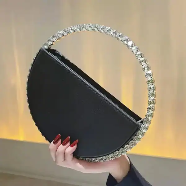 Svart rund clutch med strass och handtag, perfekt för fest och kvällskläderna.
