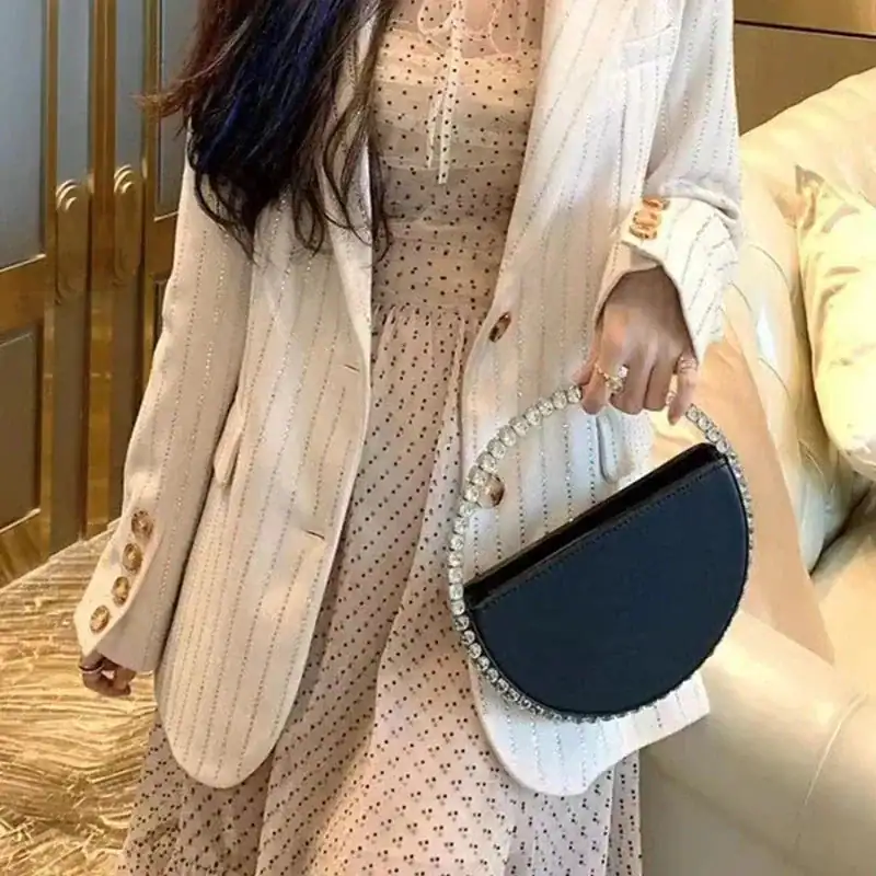 Svart rund clutch med strass, elegant axelväska för kvällskläderna.